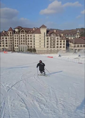 A skier turns in front of resort buildings on a Korean slope for the 2026/2027 Korea ski lesson booking announcement