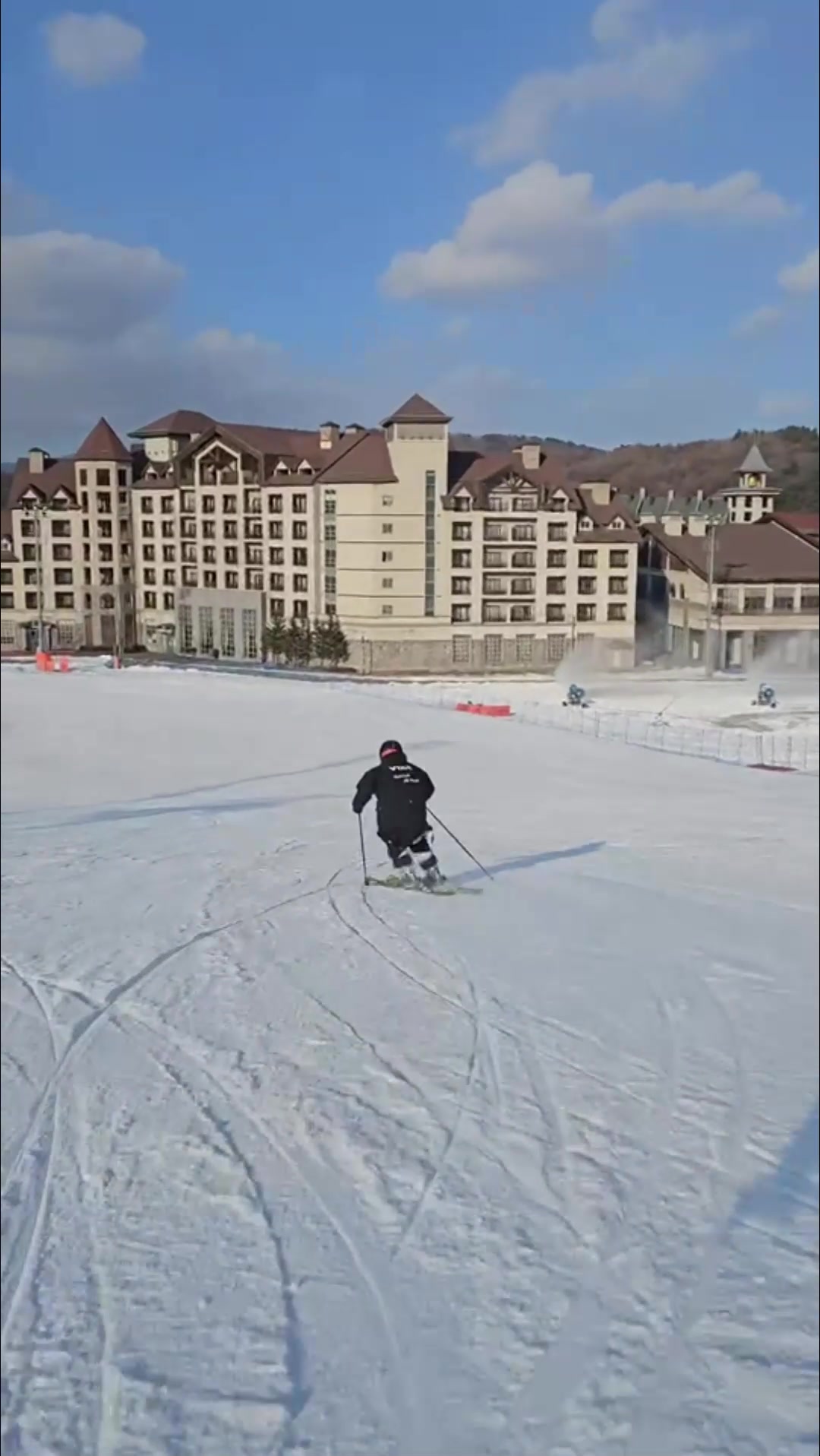 A skier turns in front of resort buildings on a Korean slope for the 2026/2027 Korea ski lesson booking announcement